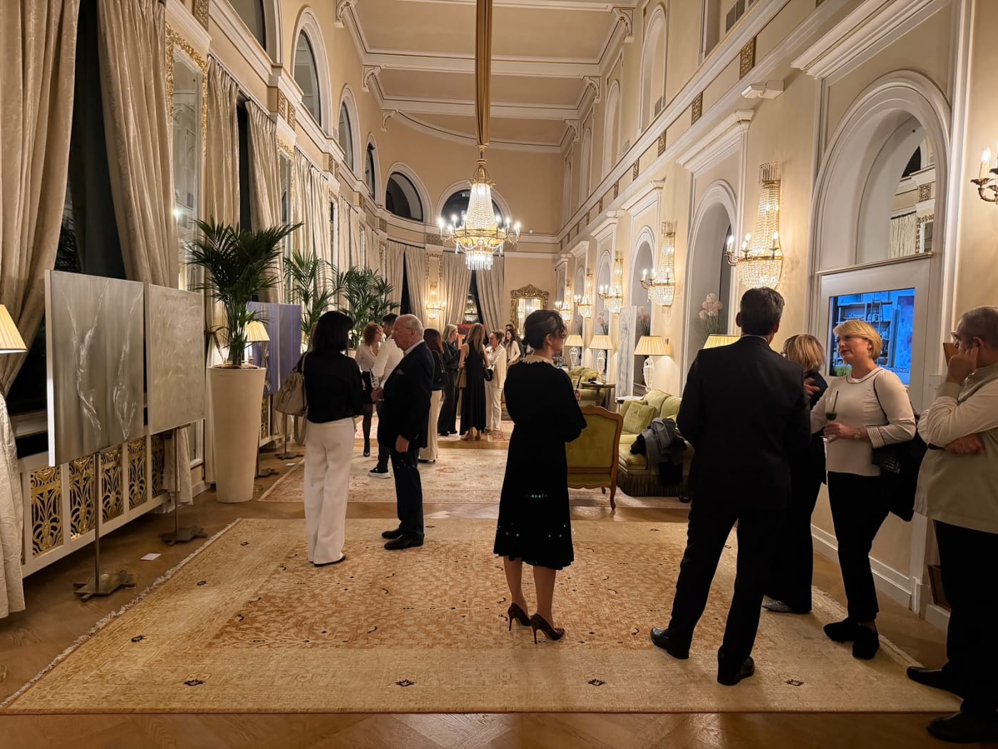 Die Galerie des Palace Merano am Abend der Vernissage, Gemälde entlang der Säulen