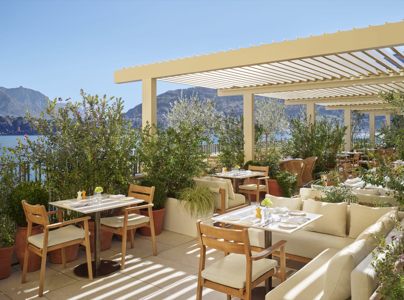 La terrasse de restaurant ombragée de l'hôtel The Lake Como EDITION au-dessus du lac de Côme