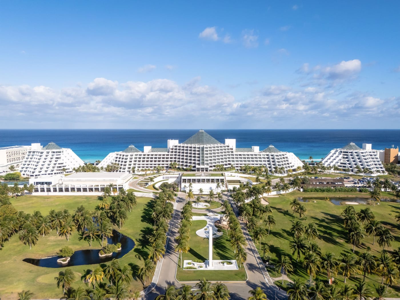 La grande pyramide de verre du Paradisus Cancún vue du ciel, entre jardins et océan