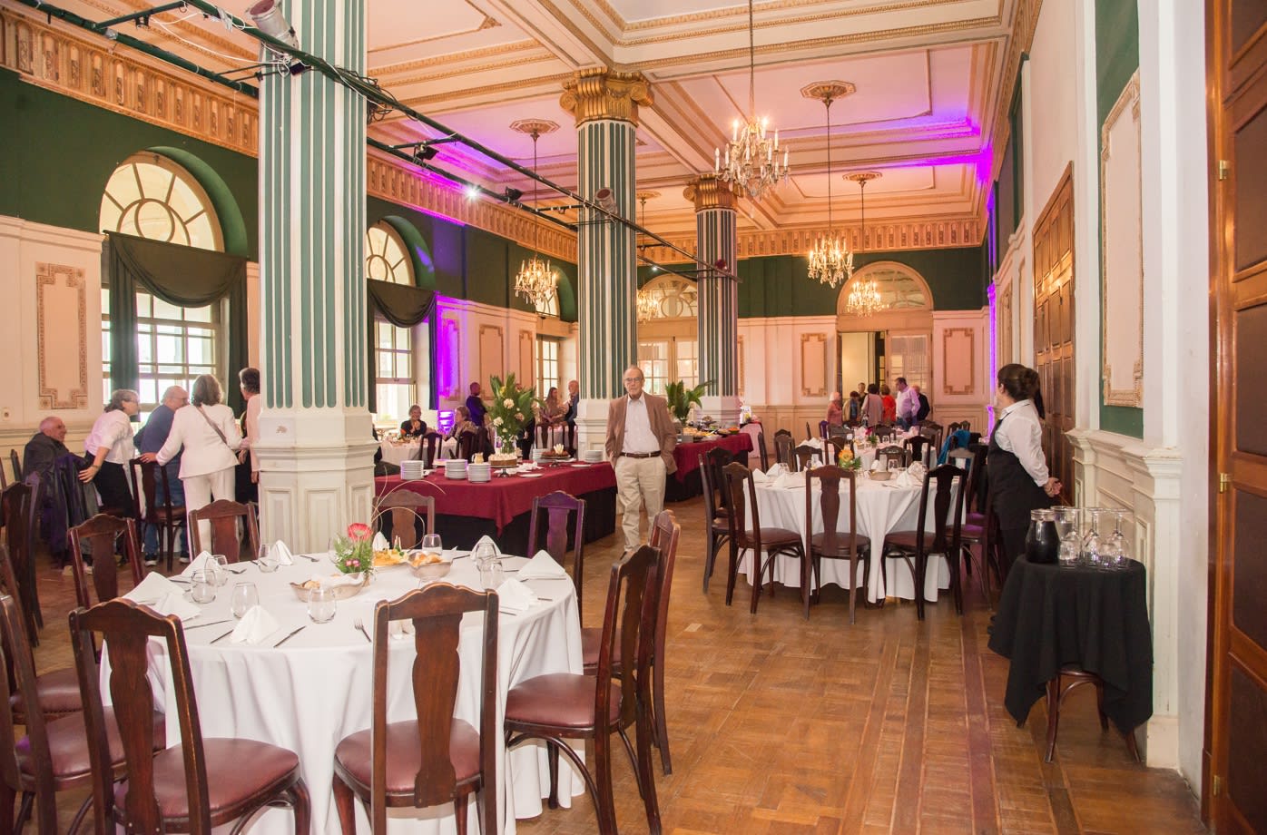 Salon historique à colonnes et lustres de l'Argentino Hotel de Piriápolis dressé pour un repas