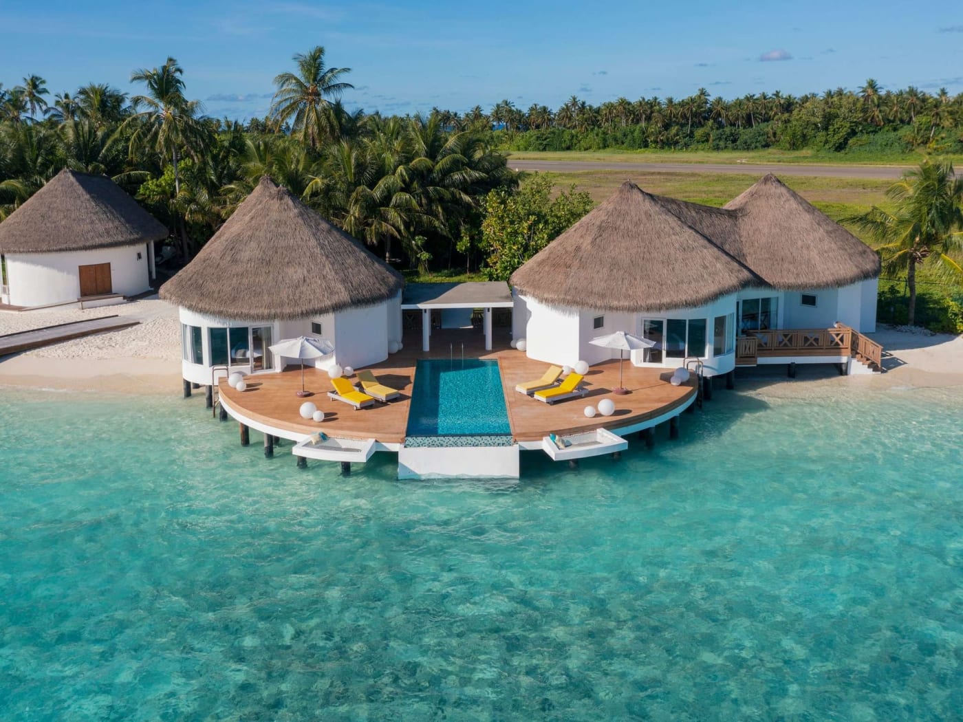 Villas sur pilotis et leur piscine au-dessus du lagon au Mercure Maldives Kooddoo Resort