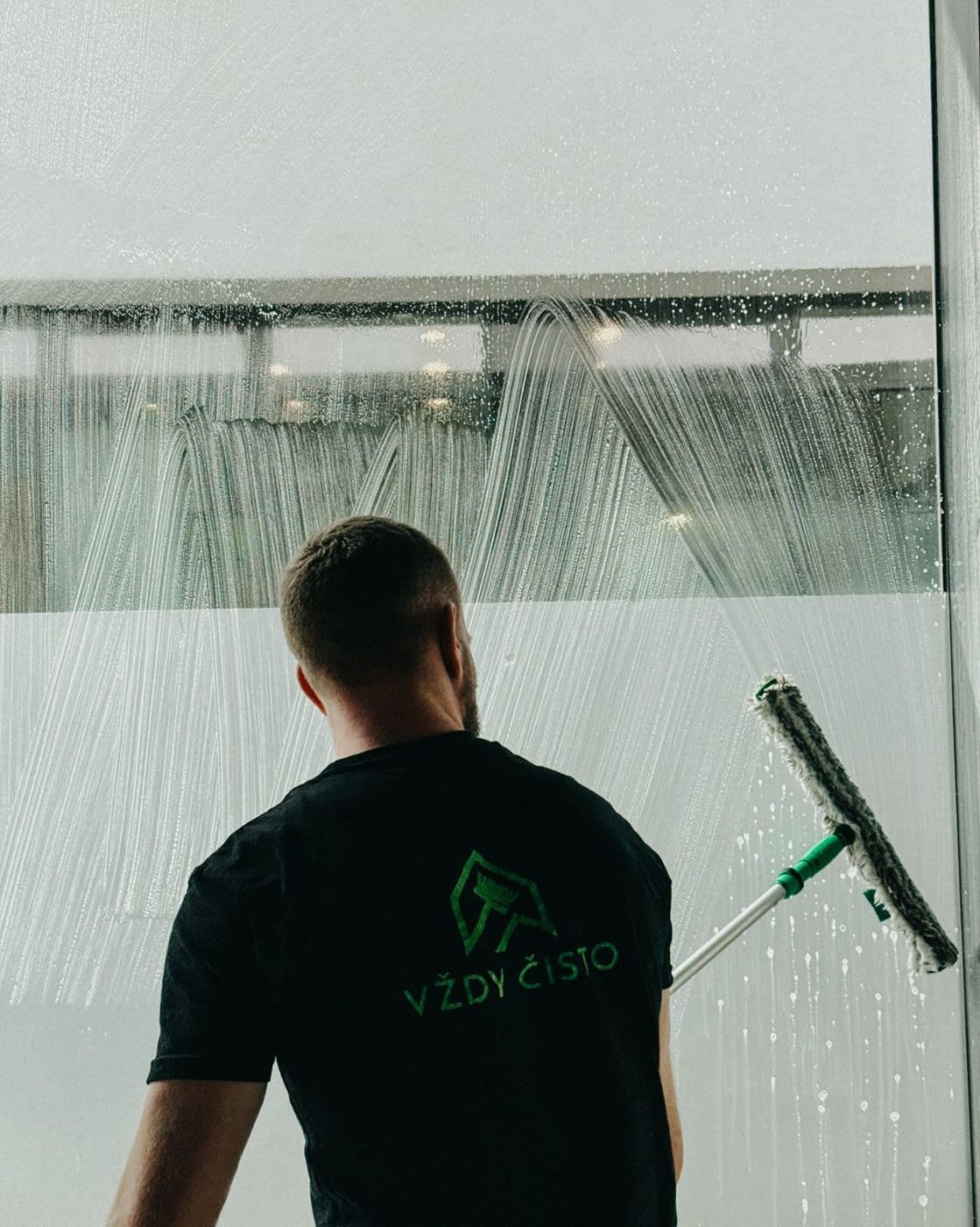 Sťahovanie vody z presklenia showroomu stierkou