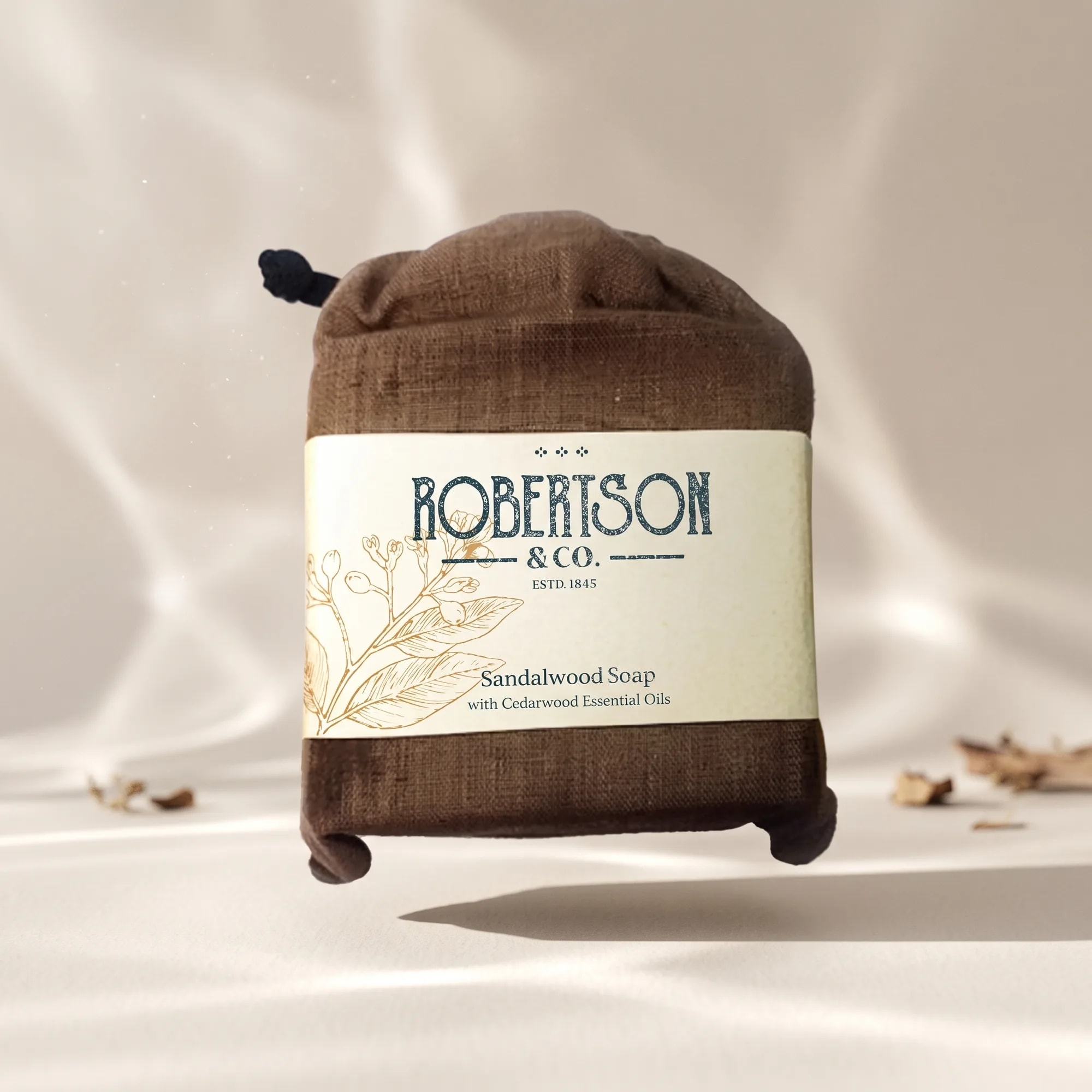 Sandalwood Soap 100g bar soap in a cotton drawstring pouch floating above an ivory surface — made in Sri Lanka, from Agromel UK