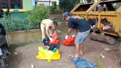 Petugas saat membersihkan limbah ke tempat pembuangan.