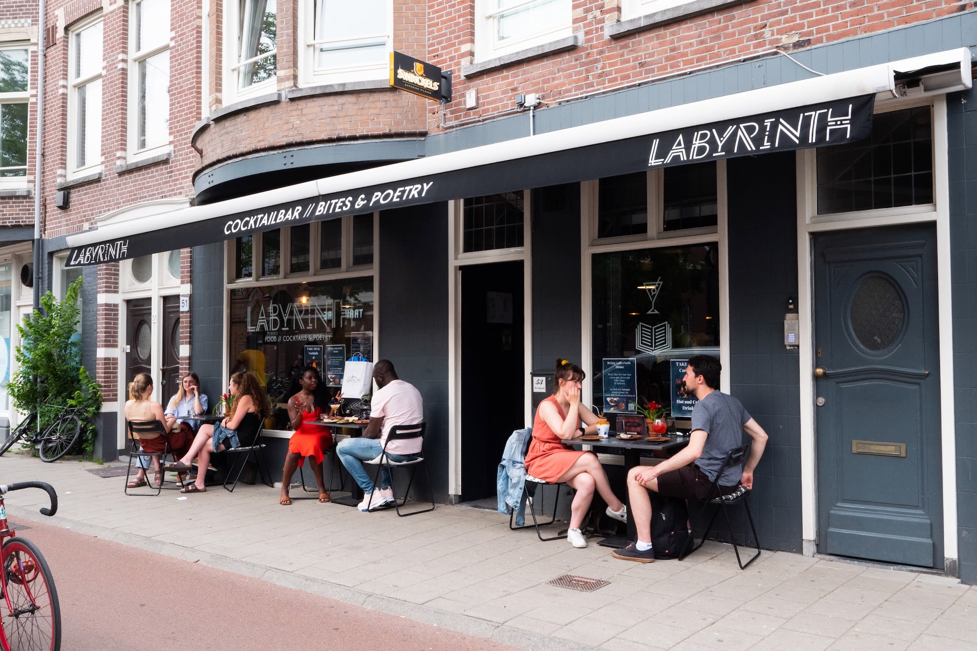 Happy diners sitting outside one of Amsterdam's best restaurants and cocktail bars- Labyrinth