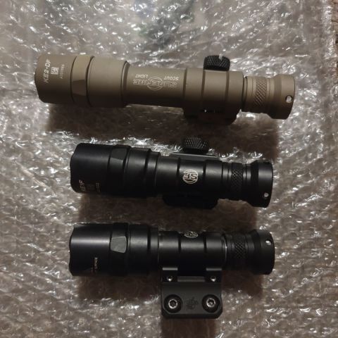 Surefire Dual Fuel in tan with KE2-DF bezel/SOLD, SF M300 with KE1F bezel and pic mount, Surefire M300 with KAC M-Lok mount and KE1F bezel.