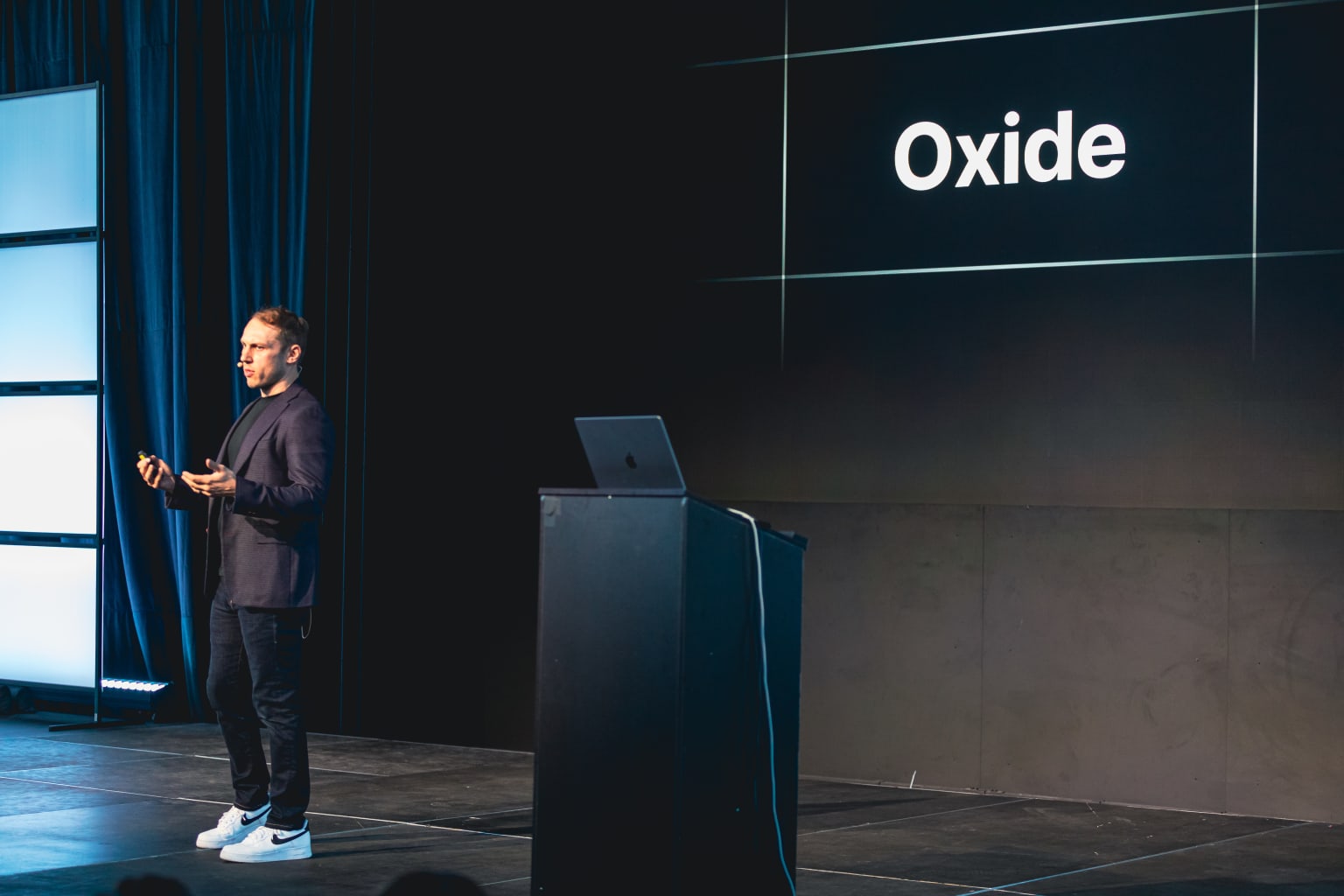 Adam Wathan on stage in front of a slide that says "Oxide"