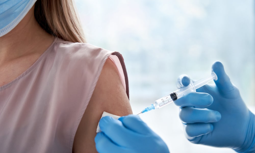 A picture of  a vaccination being injected into the arm of a woman