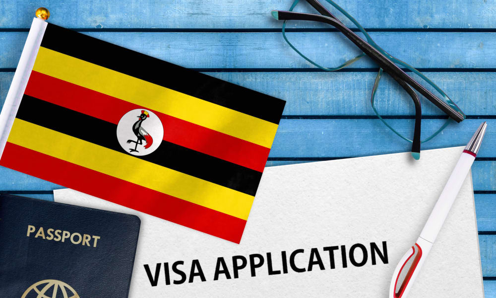 Ein Formular mit Visa Application ist neben einer Uganda Fahne zu sehen