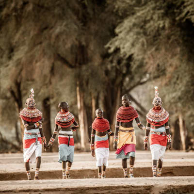 Personen in ihrer traditionellen afrikanischen Kleidung spazieren durch den kenianischen Busch