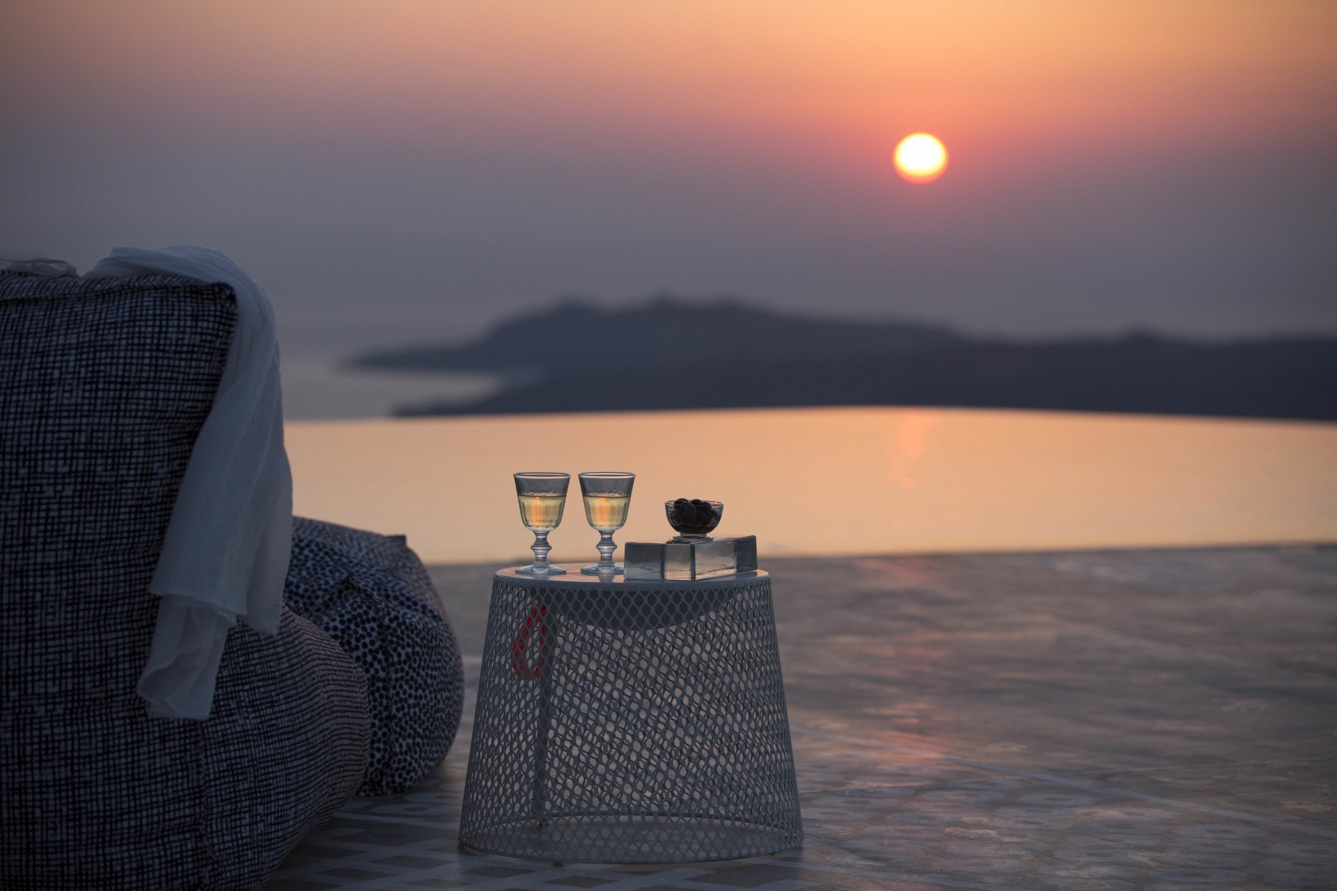 Sitzgelegenheiten am Pool mit Aussicht auf das Meer