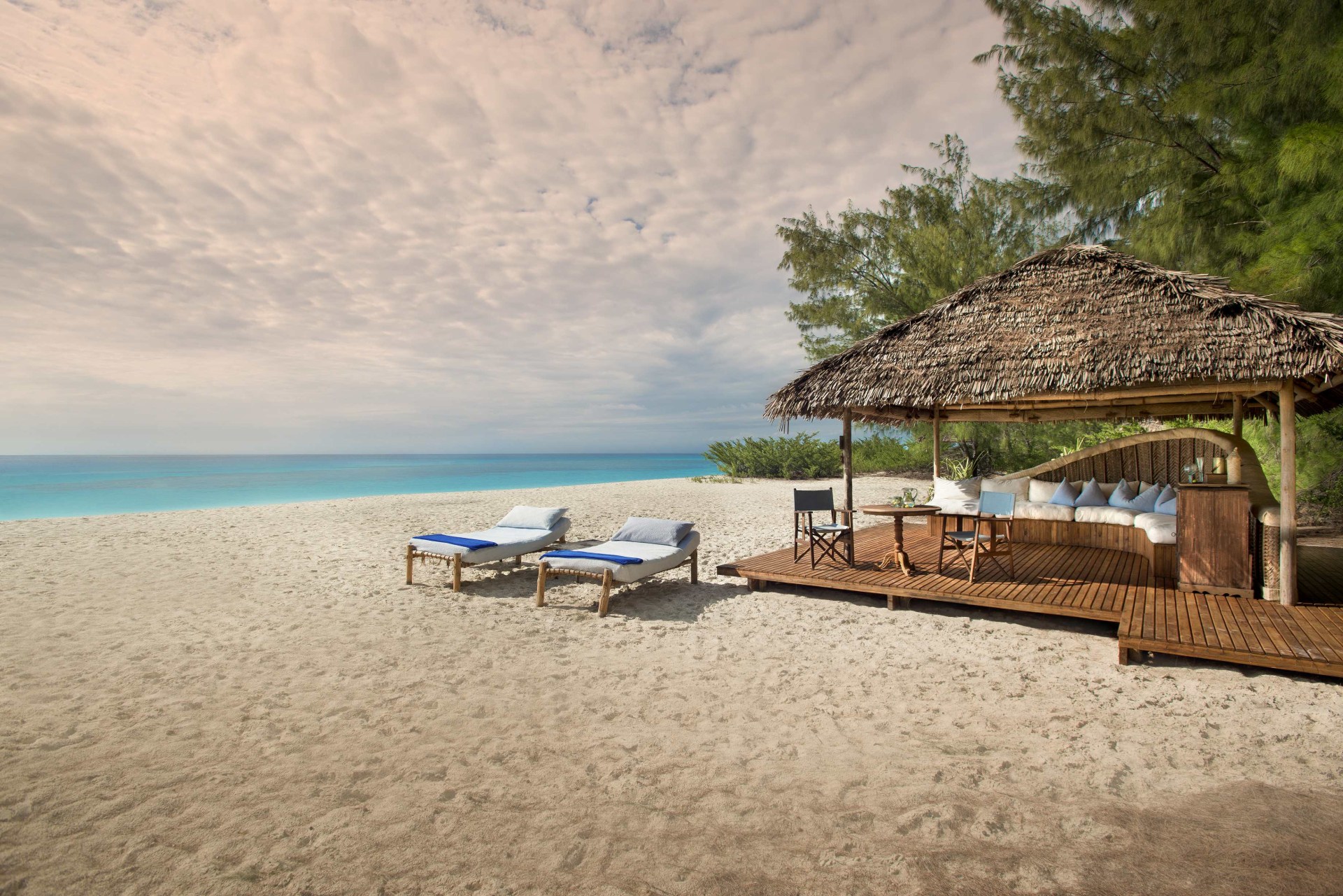 Strand mit Sonnenliegen auf Mnemba Island