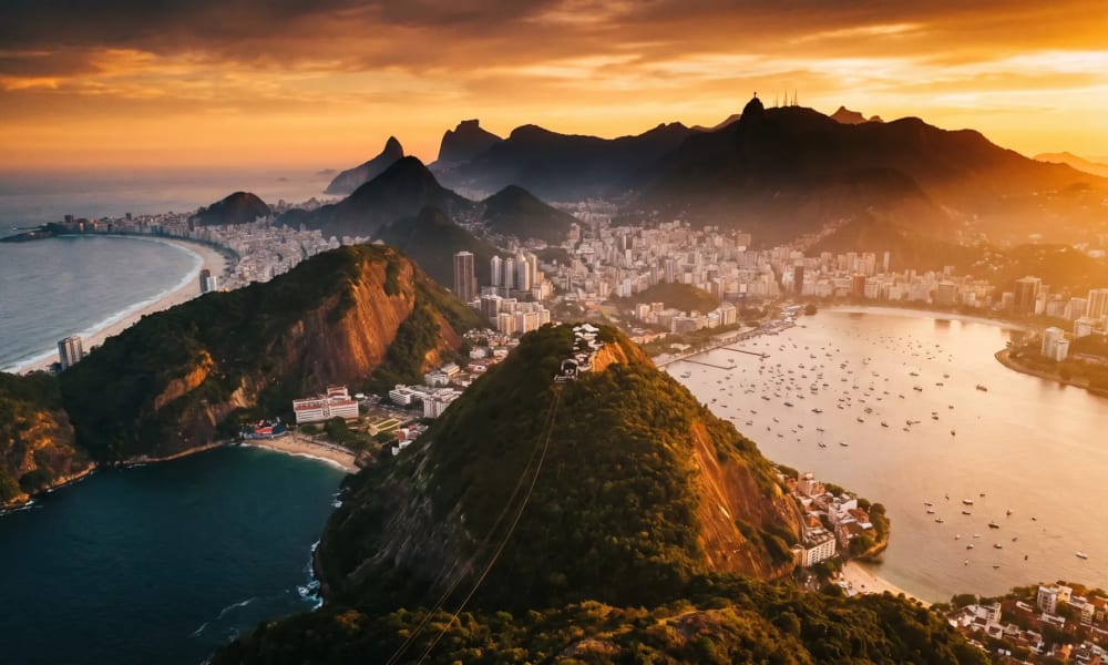 Luftaufnahme des Zuckerhuts mit der Copacabana-Bucht und dem Atlantik im warmen Licht der goldenen Stunde in Rio de Janeiro