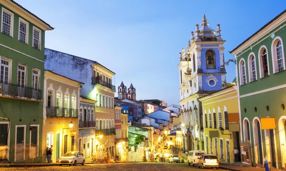 Bunte koloniale Gebäude und eine Kirche in Salvador da Bahia bei Dämmerung.
