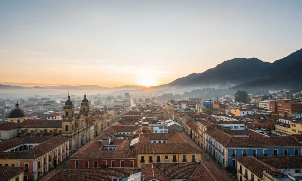 Bogotá Sightseeing — Panoramablick über die bunten Kolonialdächer von La Candelaria mit den Anden im Morgennebel