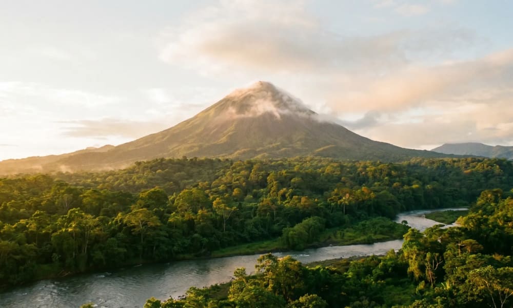 Der Vulkan Arenal hinter tropischem Regenwald in Costa Rica im goldenen Morgenlicht