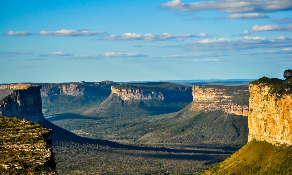 Eine Panoramaansicht der Klippen und Schlucht in der Chapada Diamantina, Brasilien, mit teilweise bewölktem Himmel.