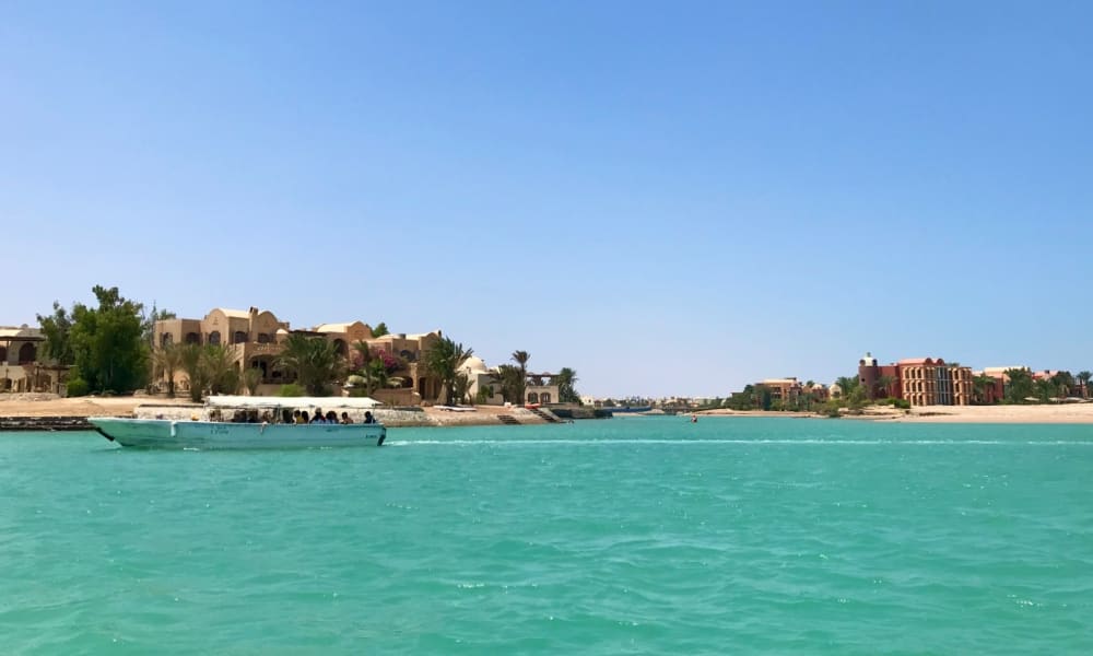 A panoramic view of El Gouna with turquoise water and modern buildings under a clear blue sky.