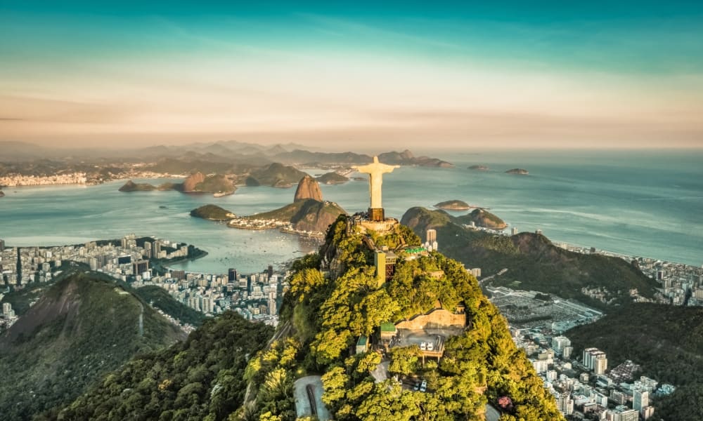 Aerial view of Rio de Janeiro featuring the Christ the Redeemer statue atop Corcovado Mountain overlooking the bay.