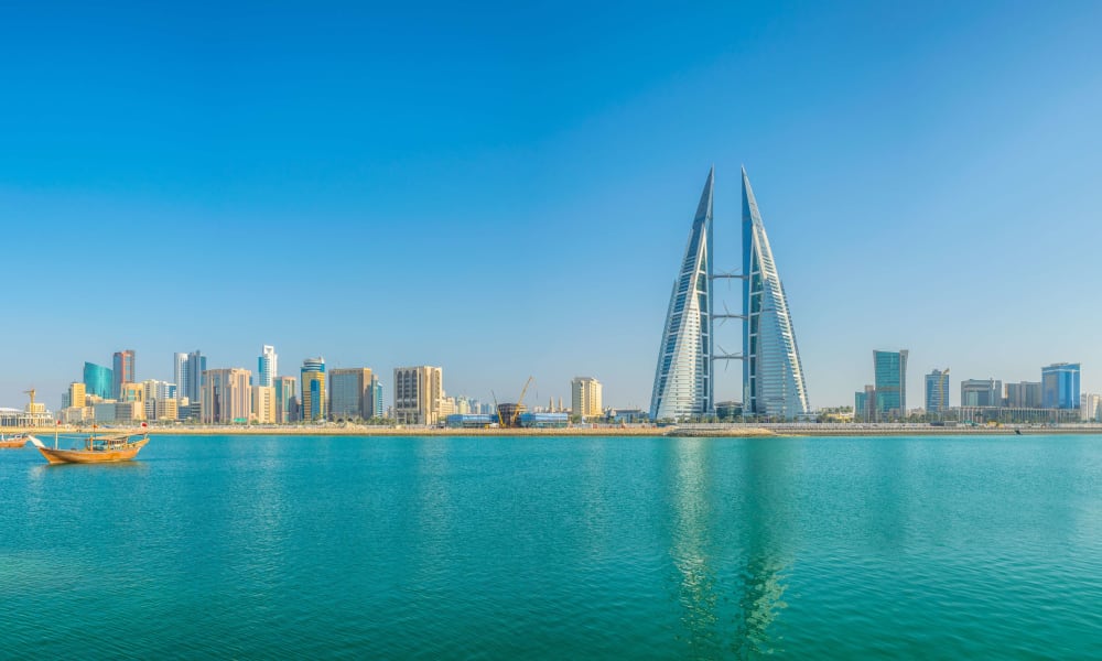 Skyline of Manama with the World Trade Center Bahrain in the center, seen across the water.