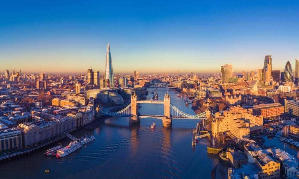 Panoramablick auf die Londoner Skyline mit der Themse, die durch die Stadt fließt, während der Sonnenuntergang.