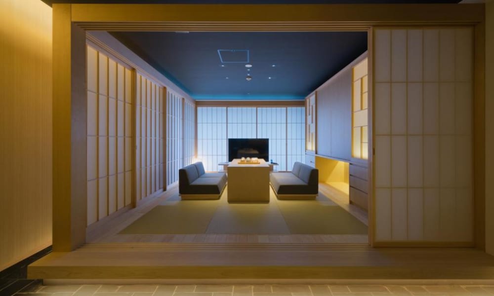 A traditional Japanese-style lounge with low seating, shoji screens, and subdued lighting inside a hotel.