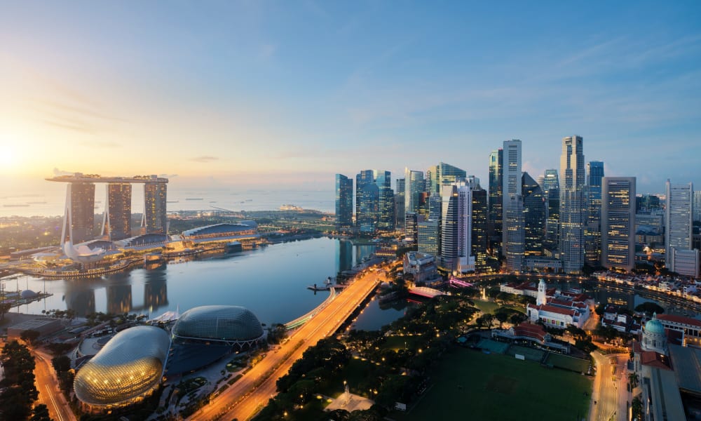 Eine Skyline des Geschäftsviertels von Singapur bei Dämmerung mit modernen Wolkenkratzern und Marina Bay Sands Hotel