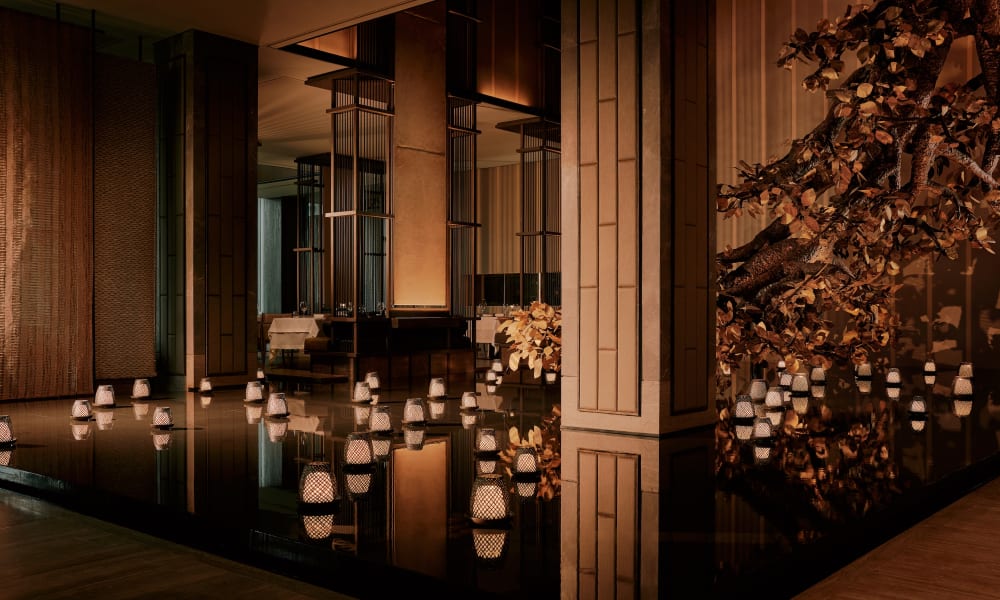 Luxurious indoor pool area with floating candles and elegant decor at Aman Nai Lert Bangkok