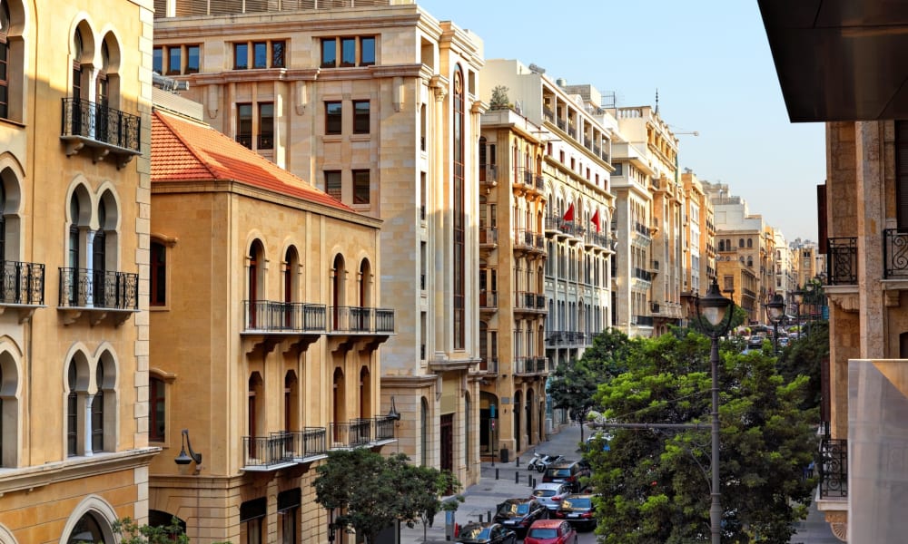 A view of a busy street in downtown Beirut with historic and modern buildings lining the street.