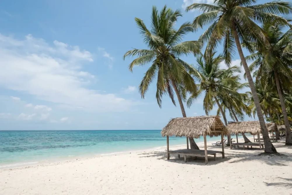 Türkisblaues Karibikwasser, weißer Sandstrand und Kokospalmen auf einer der 27 Rosario-Inseln vor Cartagena — idealer Tagesausflug beim Cartagena-Urlaub