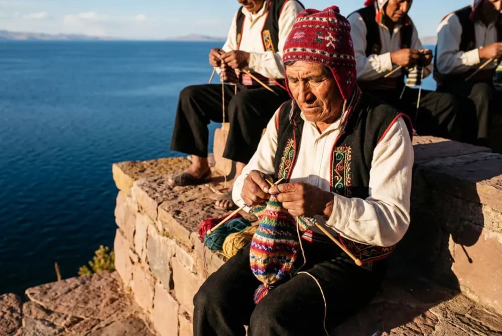 Taquile-Männer in traditioneller Tracht beim Stricken ihrer Chullo-Mützen am Titicacasee