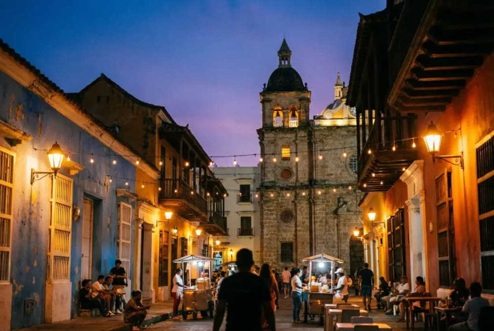 Abendliche Szene auf der Plaza de la Trinidad in Getsemaní mit Straßenmusikern, bunten Hausfassaden und karibischem Lebensgefühl