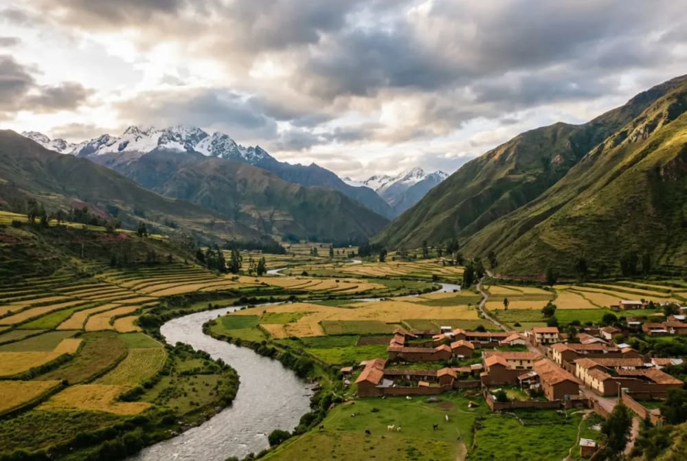 Panorama des Heiligen Tals in Peru mit Terrassenfeldern, dem Urubamba-Fluss und den Anden im Hintergrund