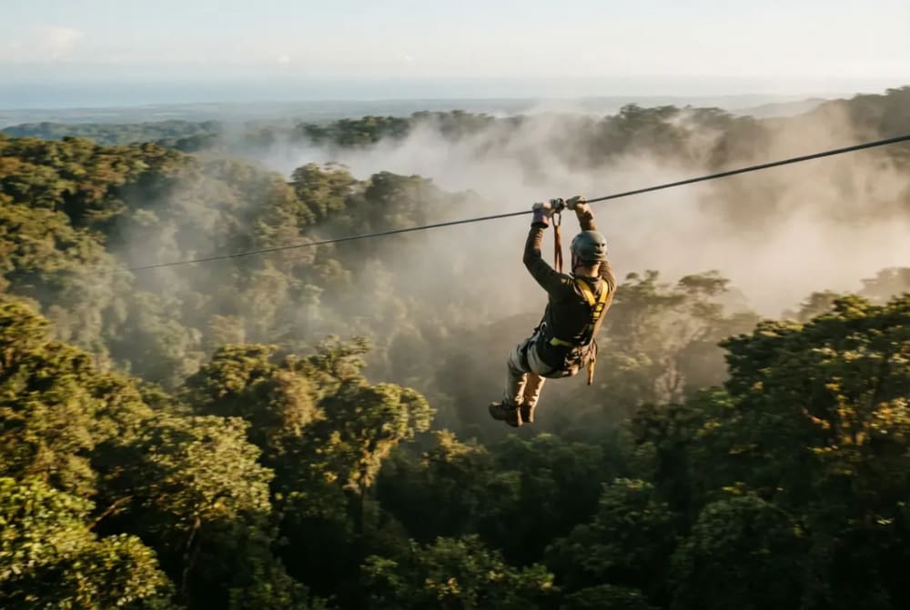 Zipline-Fahrt über dem Nebelwald-Canopy von Monteverde mit Blick auf die Baumkronen