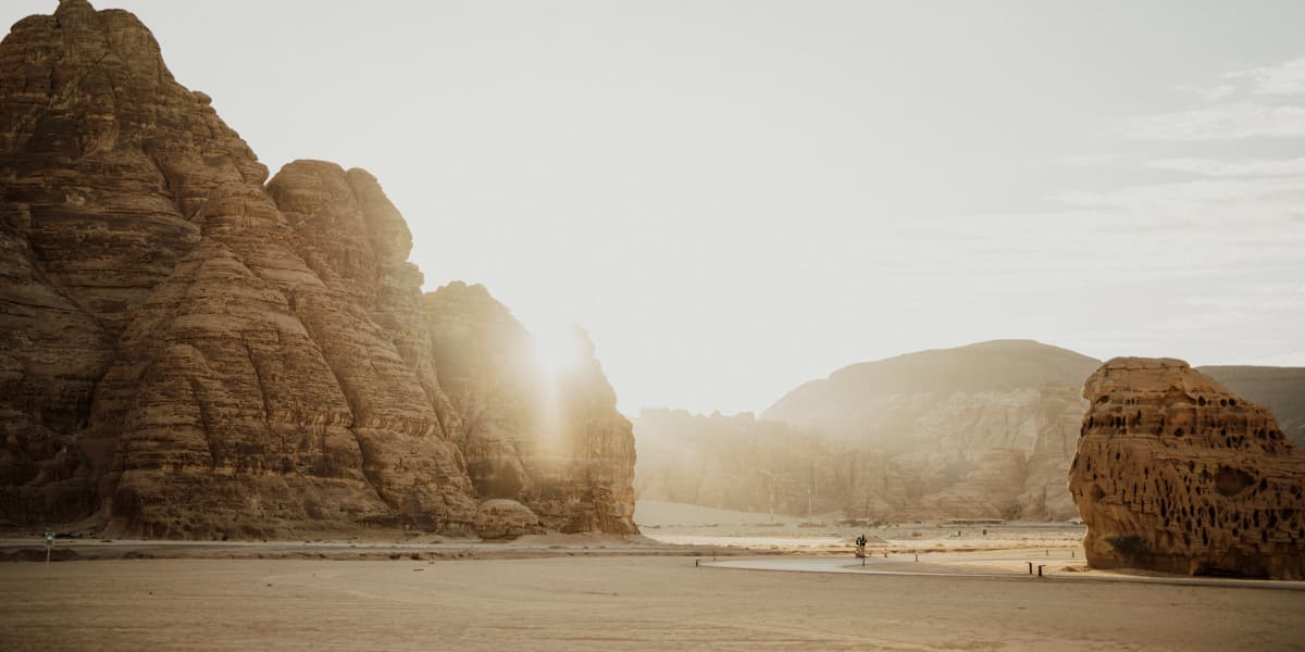 Sunset over rugged sandstone formations in Al-Ula desert.