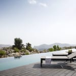 Luxuriöser Poolbereich mit modernen Sonnenliegen und malerischem Bergblick im Hintergrund.
