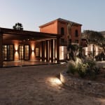 Elegantes Gebäude mit warmem Licht in einer begrünten Umgebung bei Dämmerung in El Gouna.
