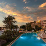 Luxuriöser Hotelpool mit Blick auf den Nil bei Sonnenuntergang in Aswan.