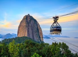 Eine Seilbahn schwebt am Himmel mit dem Zuckerhut im Hintergrund in Rio de Janeiro, Brasilien.