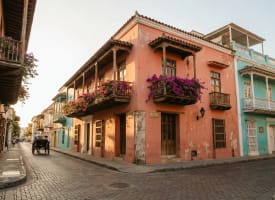 Bunte Kolonialfassaden mit blühendem Bougainvillea in Cartagenas UNESCO-geschützter Altstadt im warmen Licht der Abendsonne