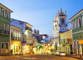 Bunte koloniale Gebäude und eine Kirche in Salvador da Bahia bei Dämmerung.
