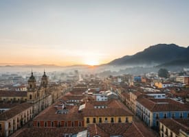 Bogotá Sightseeing — Panoramablick über die bunten Kolonialdächer von La Candelaria mit den Anden im Morgennebel