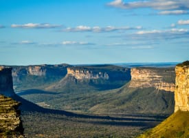 Eine Panoramaansicht der Klippen und Schlucht in der Chapada Diamantina, Brasilien, mit teilweise bewölktem Himmel.