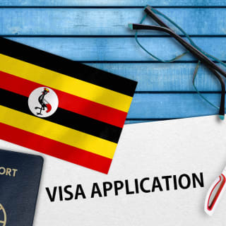 Ein Formular mit Visa Application ist neben einer Uganda Fahne zu sehen
