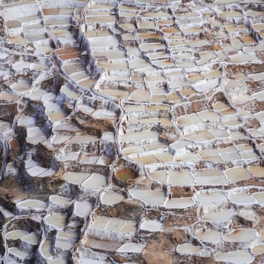 Terrassierte Salztümpel an einem Hang in Maras, Cusco, Peru, mit verschiedenen Stadien der Salzkrustenbildung.