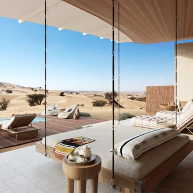 Open-Air-Lounge mit Schaukelstühlen, die auf eine Wüstenlandschaft mit Sanddünen und spärlicher Vegetation blicken.