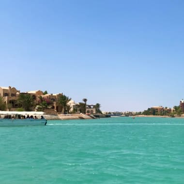 A panoramic view of El Gouna with turquoise water and modern buildings under a clear blue sky.