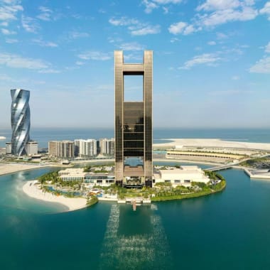 Luftaufnahme des Four Seasons Hotels Bahrain Bay mit hohen modernen Wolkenkratzern und Wasser, das die Insel des Hotels umgibt.