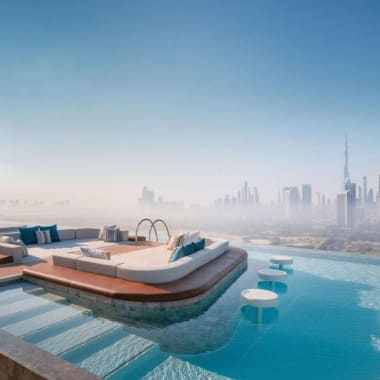 Luxuriöser Dachpool mit Blick auf die Skyline von Dubai, mit modernem Sitzbereich und schwimmenden Hockern.