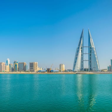 Skyline of Manama with the World Trade Center Bahrain in the center, seen across the water.
